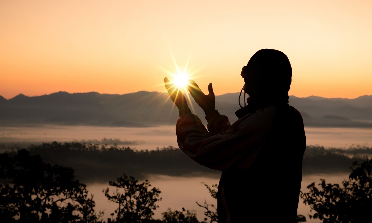 Peaceful sunrise with an open Bible and hands in prayer, representing powerful January morning prayers with hope and faith