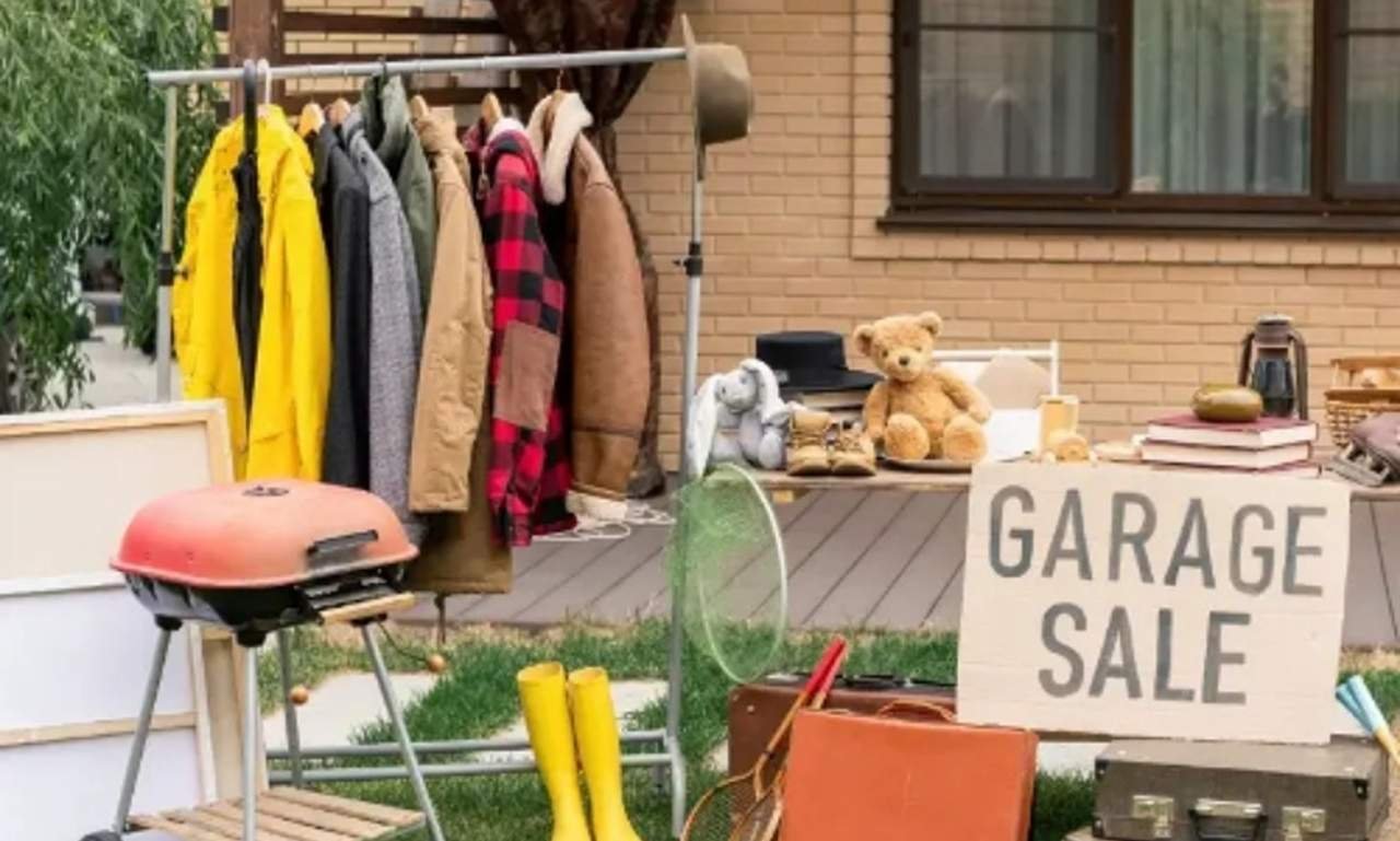 Colorful garage sale setup with funny blessing quotes, handwritten price tags, smiling shoppers, and uplifting messages about faith, hope, and perseverance.